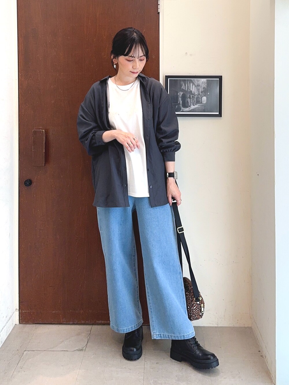 ホワイト系のTシャツ/カットソー、グレー系のシャツ/ブラウス、ブルー系のデニムパンツを着用したレディースの秋コーディネートの2枚目の写真