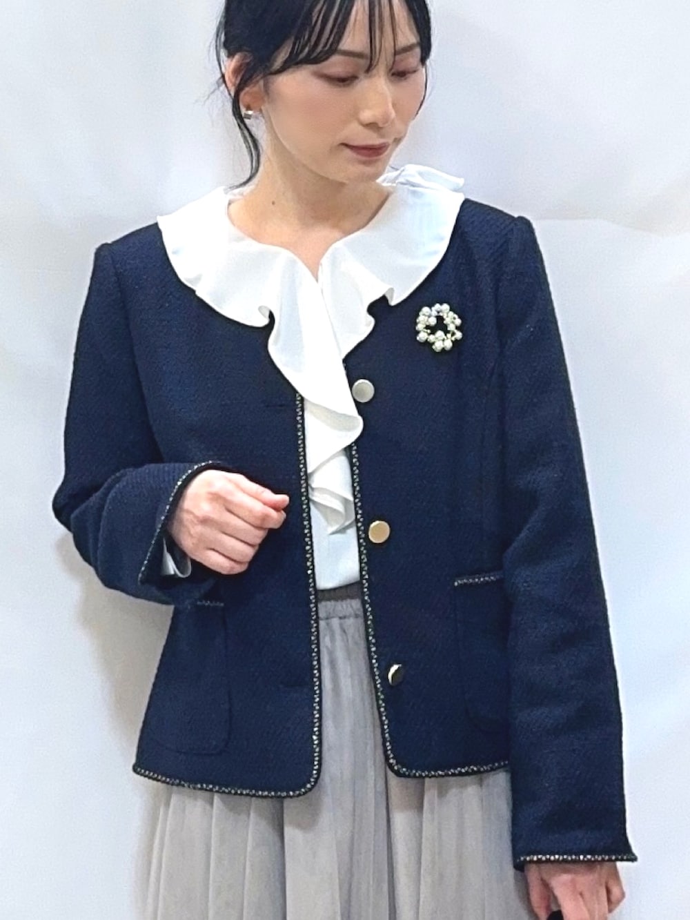 ブルー系のノーカラージャケット、ホワイト系のシャツ/ブラウス、ベージュ系のスカートを着用したレディースの冬コーディネートの5枚目の写真