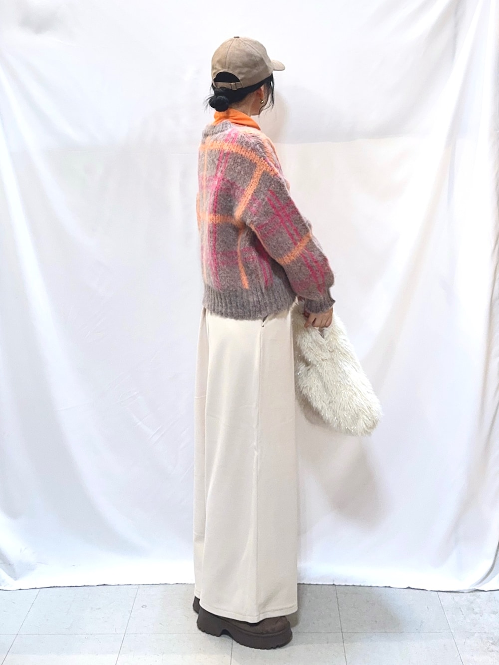 ピンク系のニット/セーター、ホワイト系のその他パンツ、ホワイト系のトートバッグを着用したレディースの秋コーディネートの2枚目の写真