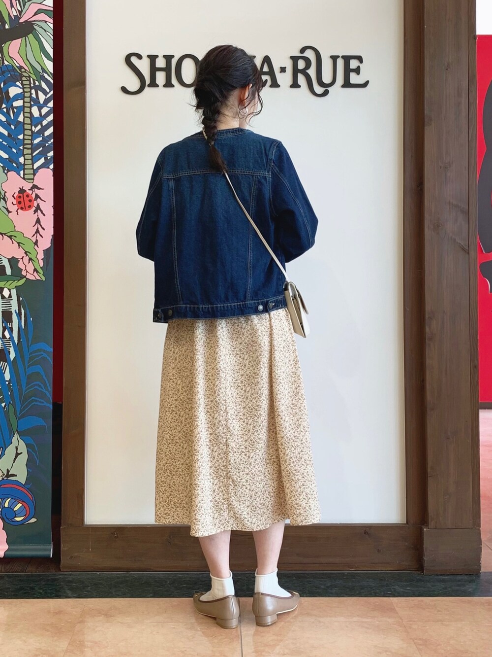 ベージュ系のワンピース、ブルー系のデニムジャケット、ベージュ系のショルダーバッグを着用したレディースの冬コーディネートの2枚目の写真