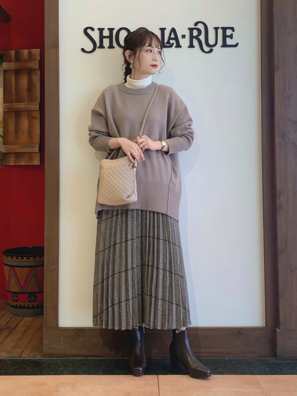 ベージュ系のニット/セーター、ホワイト系のTシャツ/カットソー、ブラウン系のスカートを着用したレディースの冬コーディネートの2枚目の写真