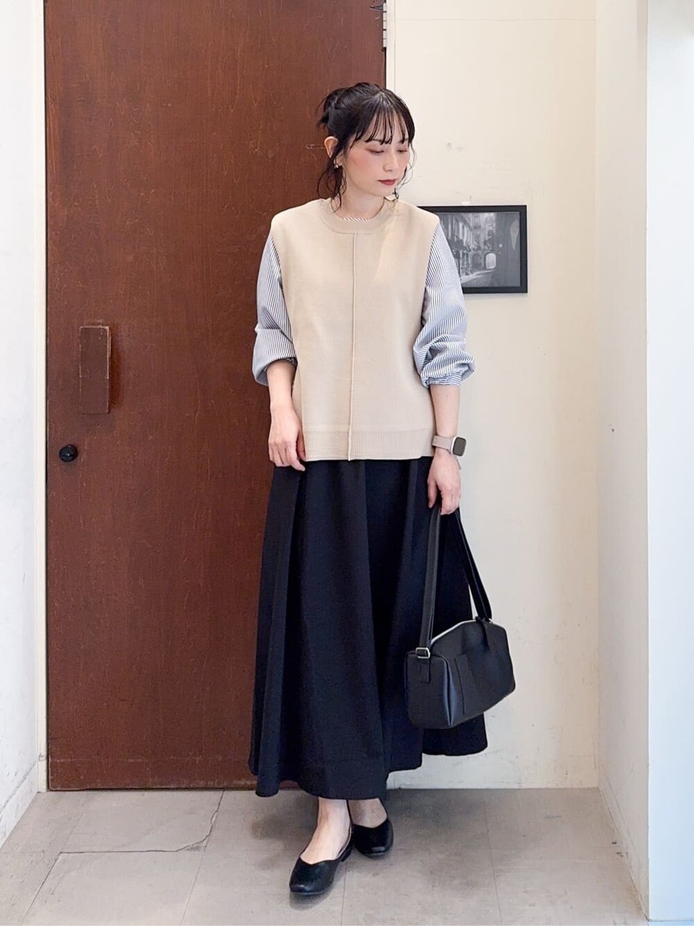 ベージュ系のその他トップス、ブラック系のスカート、ブラック系のその他シューズを着用したレディースの春コーディネートの2枚目の写真