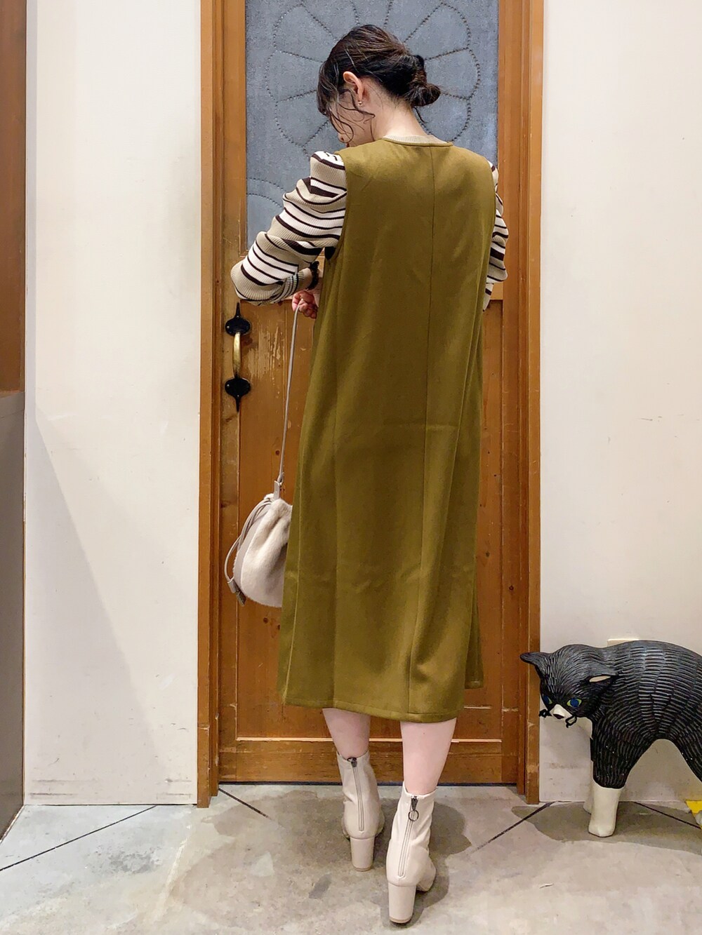 ベージュ系のニット/セーター、イエロー系のスカート、ベージュ系のショルダーバッグを着用したレディースの冬コーディネートの4枚目の写真