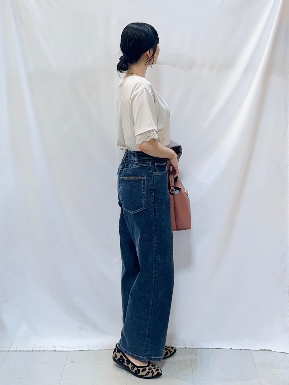 ブラウン系のテーラードジャケット、ベージュ系のTシャツ/カットソー、ブルー系のデニムパンツを着用したレディースの秋コーディネートの5枚目の写真