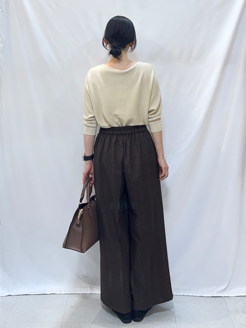 ホワイト系のニット/セーター、ブラウン系のその他パンツ、ブラック系のパンプスを着用したレディースの秋コーディネートの3枚目の写真