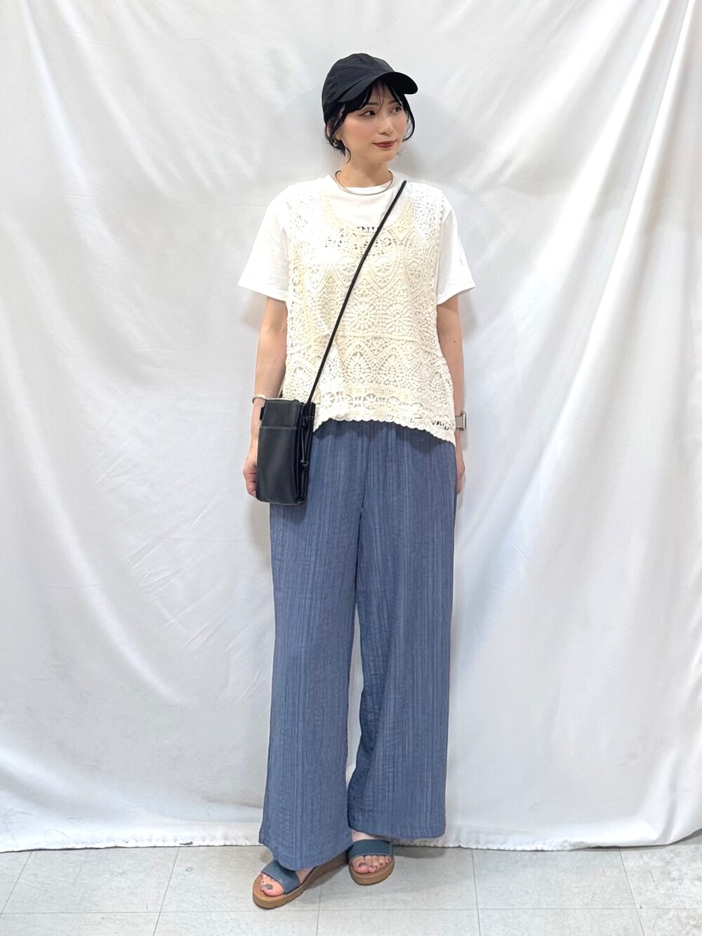 ブルー系のその他パンツ、ブルー系のサンダル、ブラック系のショルダーバッグを着用したレディースの夏コーディネートの3枚目の写真