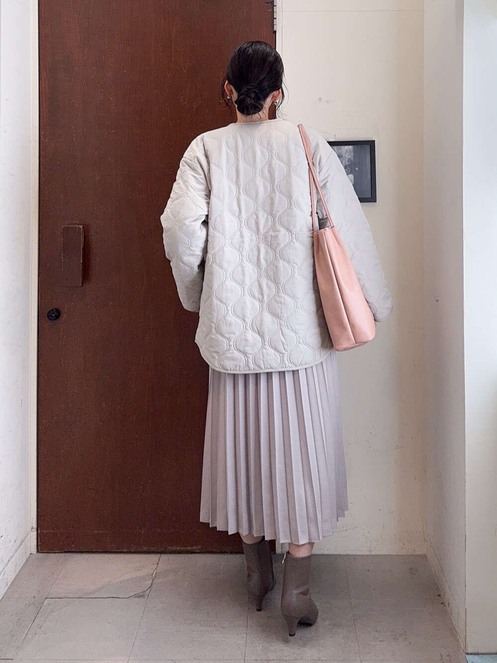 ベージュ系のブルゾン、ブルー系のニット/セーター、ベージュ系のスカートを着用したレディースの冬コーディネートの3枚目の写真