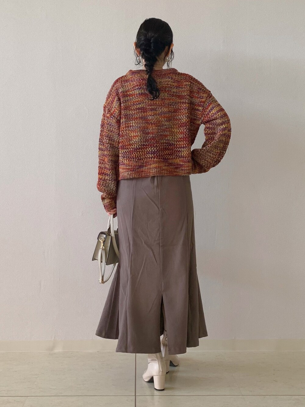 ベージュ系のTシャツ/カットソー、ピンク系のカーディガン/ボレロ、ブラウン系のスカートを着用したレディースの秋コーディネートの3枚目の写真