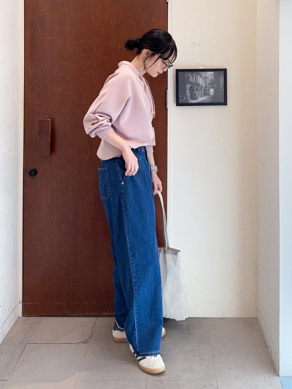 ピンク系のTシャツ/カットソー、ブルー系のデニムパンツ、ベージュ系のトートバッグを着用したレディースの冬コーディネートの2枚目の写真