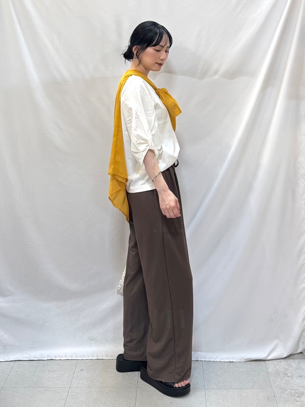 イエロー系のシャツ/ブラウス、ホワイト系のTシャツ/カットソー、ブラウン系のその他パンツを着用したレディースの夏コーディネートの4枚目の写真