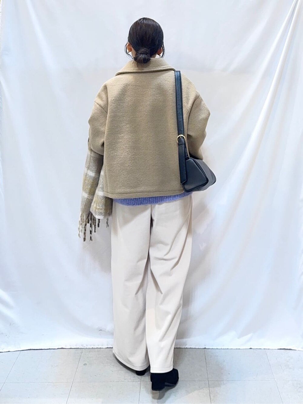 ベージュ系のブルゾン、ブルー系のニット/セーター、ホワイト系のその他パンツを着用したレディースの冬コーディネートの4枚目の写真