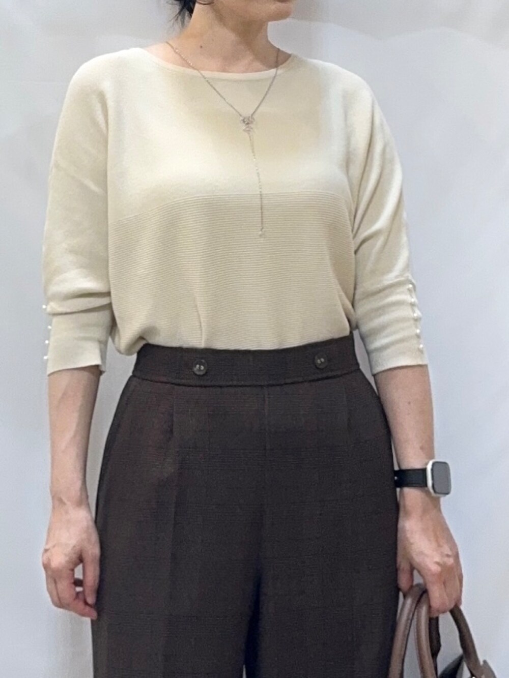 ホワイト系のニット/セーター、ブラウン系のその他パンツ、ブラック系のパンプスを着用したレディースの秋コーディネートの7枚目の写真
