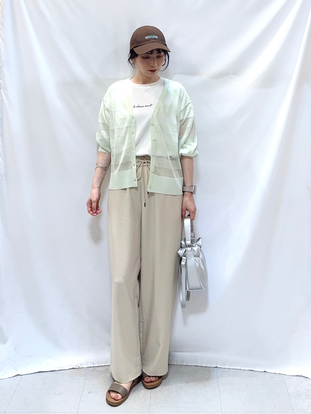 グリーン系のカーディガン/ボレロ、ホワイト系のTシャツ/カットソー、ベージュ系のその他パンツを着用したレディースの夏コーディネートの3枚目の写真