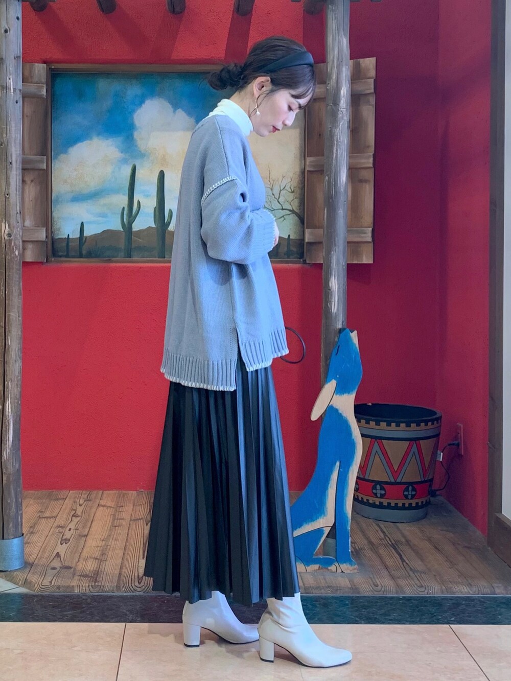 ブルー系のニット/セーター、ホワイト系のTシャツ/カットソー、ブラック系のスカートを着用したレディースの秋コーディネートの3枚目の写真