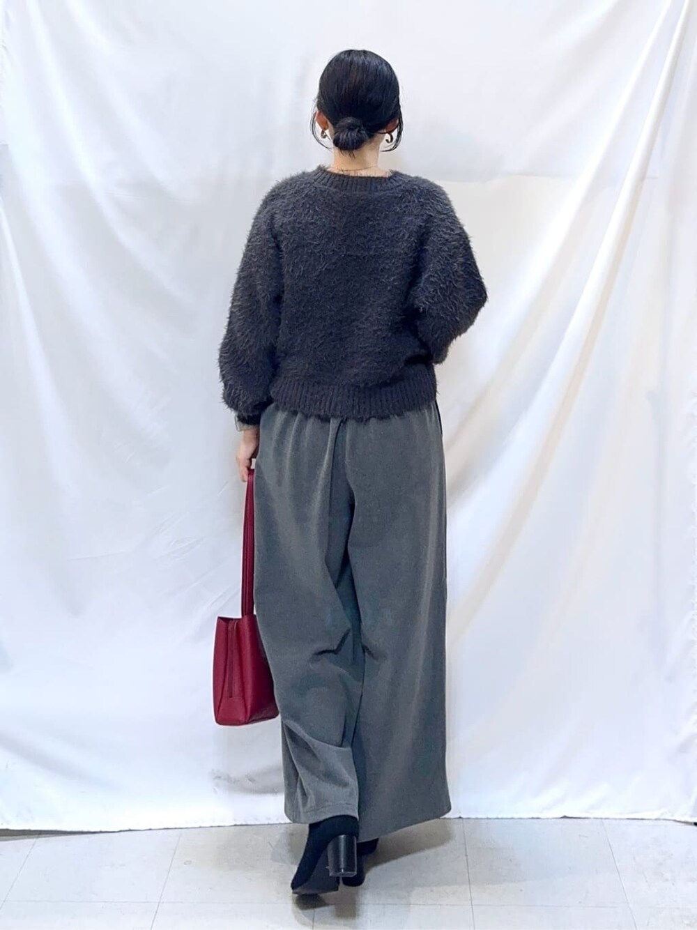 グレー系のニット/セーター、グレー系のその他パンツ、ブラック系のブーツを着用したレディースの冬コーディネートの4枚目の写真