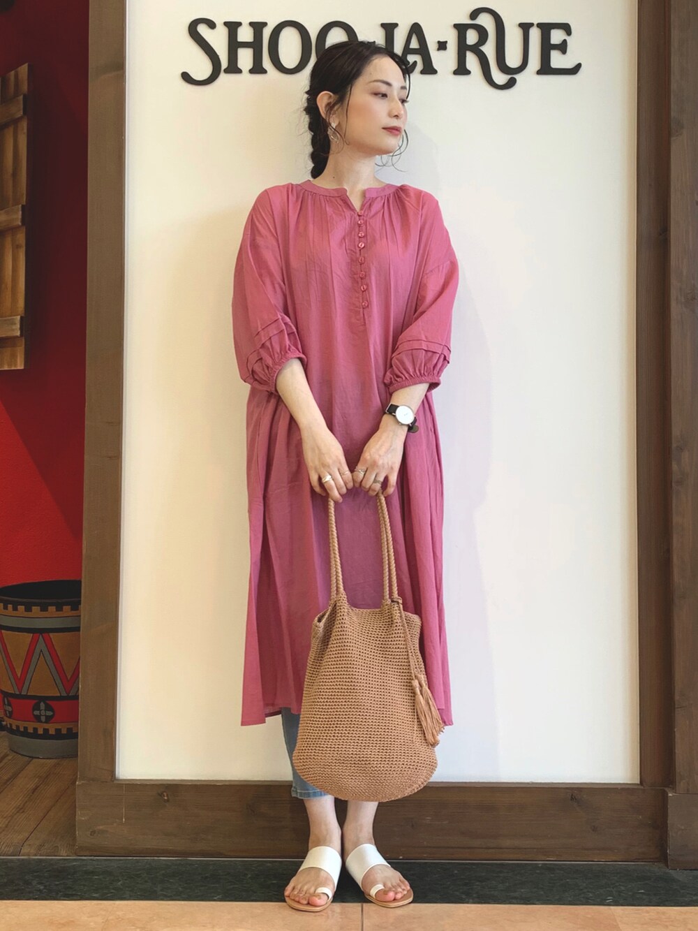 ピンク系のワンピース、オレンジ系のトートバッグ、ホワイト系のサンダルを着用したレディースの春コーディネートの2枚目の写真