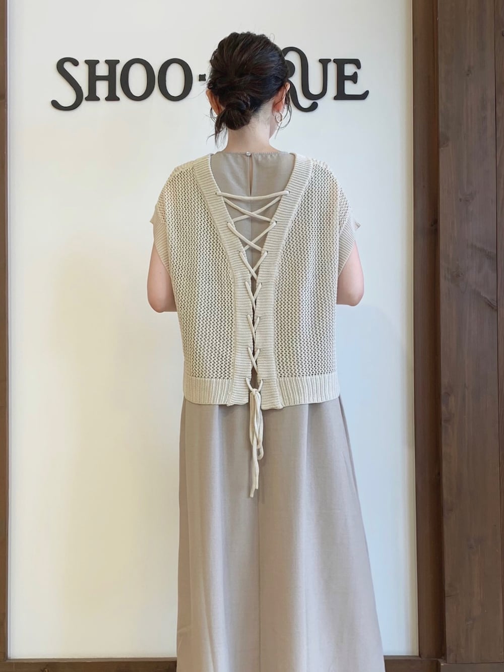 ベージュ系のワンピース、ベージュ系のニット/セーター、ブラック系のショルダーバッグを着用したレディースの夏コーディネートの2枚目の写真