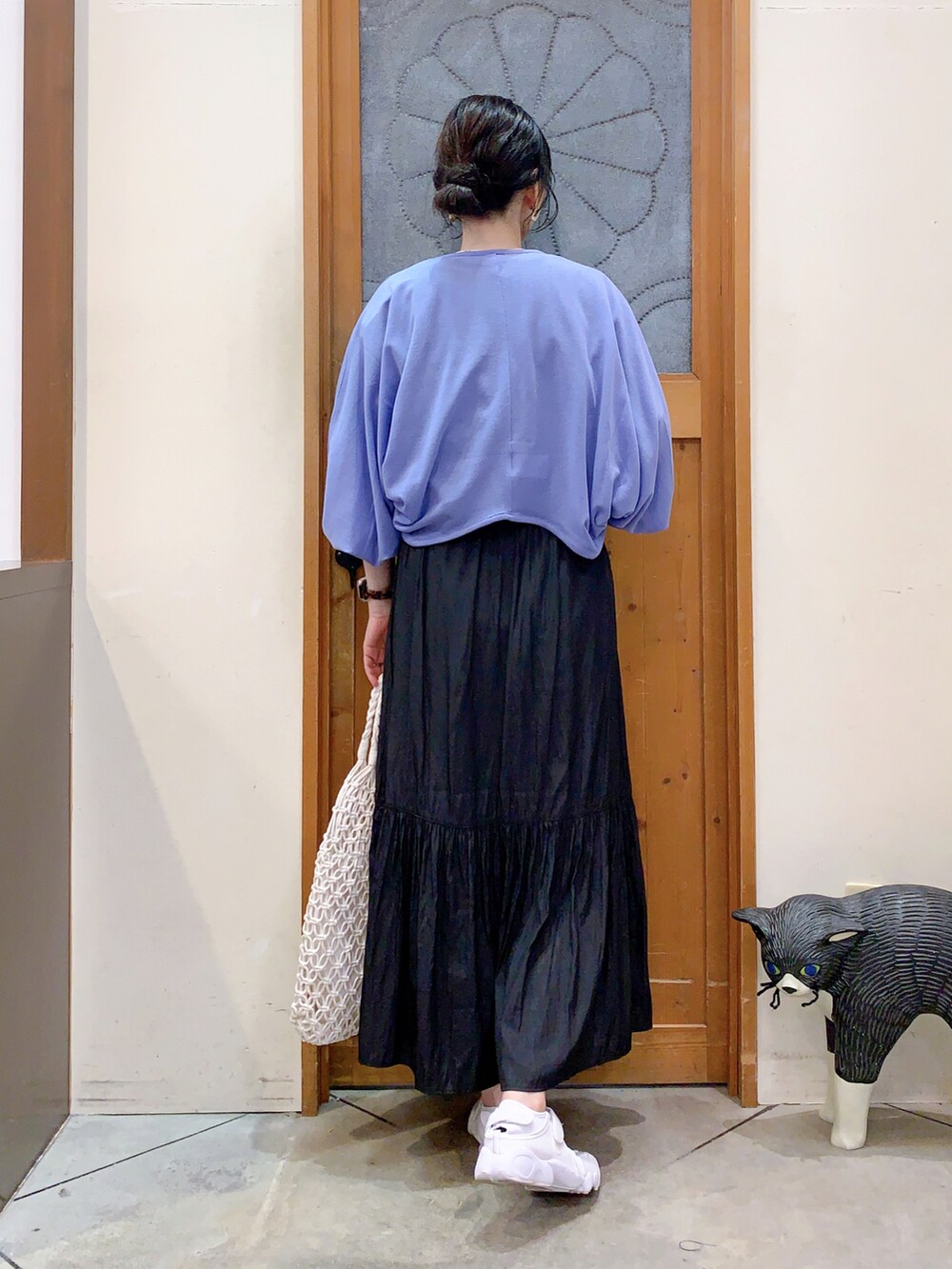 ブラック系のTシャツ/カットソー、ブルー系のカーディガン/ボレロ、ブラック系のスカートを着用したレディースの春コーディネートの4枚目の写真