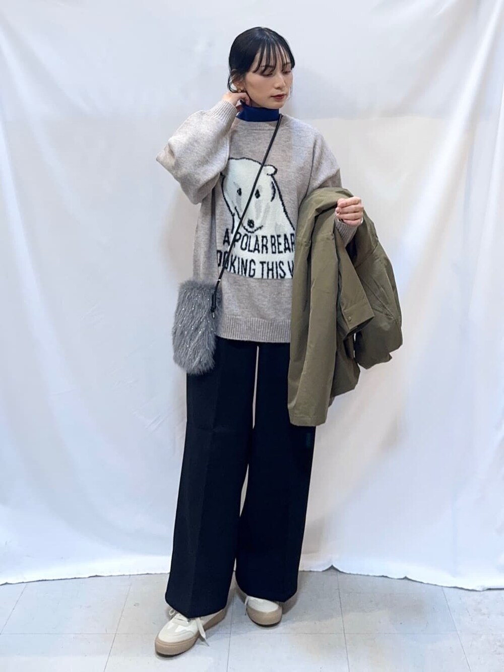 グリーン系のミリタリージャケット、グレー系のニット/セーター、ブルー系のニット/セーターを着用したレディースの冬コーディネートの5枚目の写真