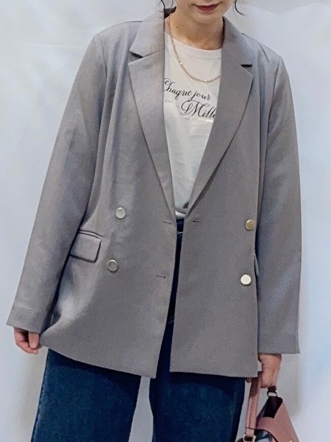 ブラウン系のテーラードジャケット、ベージュ系のTシャツ/カットソー、ブルー系のデニムパンツを着用したレディースの秋コーディネートの8枚目の写真