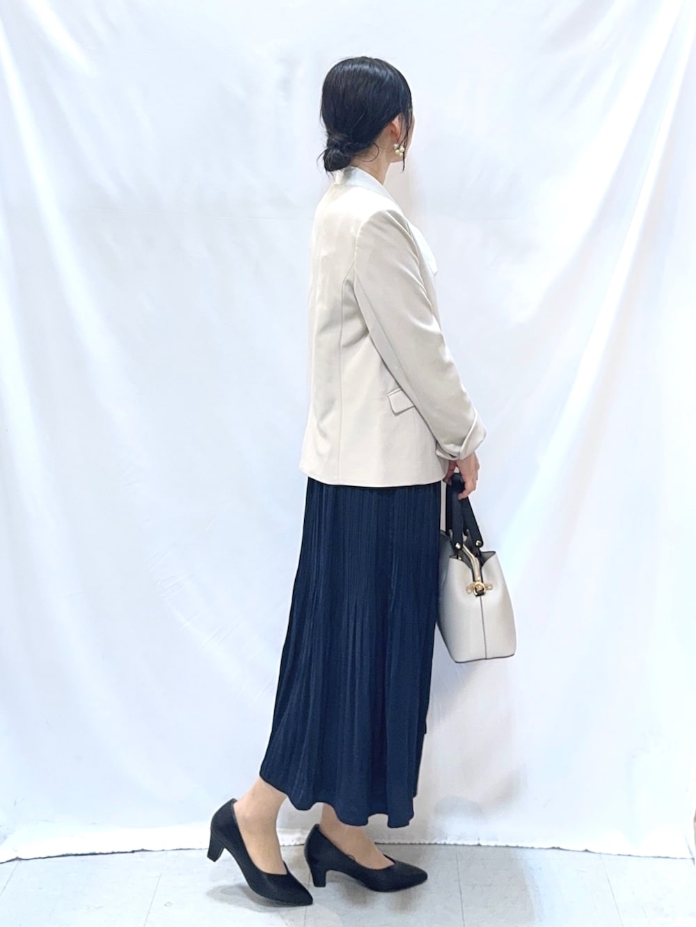 ベージュ系のノーカラージャケット、ホワイト系のシャツ/ブラウス、ブルー系のスカートを着用したレディースの冬コーディネートの2枚目の写真