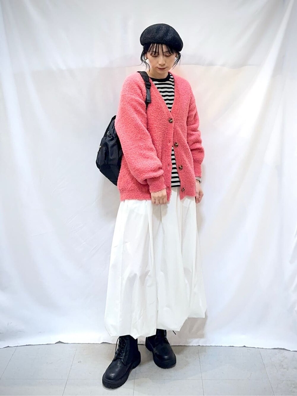 ピンク系のカーディガン/ボレロ、ブラック系のTシャツ/カットソー、ホワイト系のスカートを着用したレディースの秋コーディネートの3枚目の写真