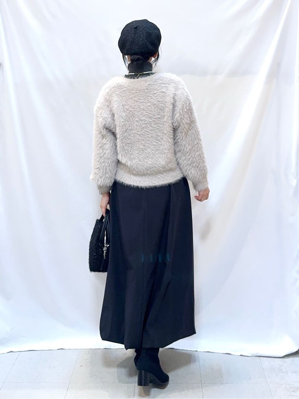 グレー系のカーディガン/ボレロ、グレー系のニット/セーター、ブラック系のスカートを着用したレディースの冬コーディネートの4枚目の写真