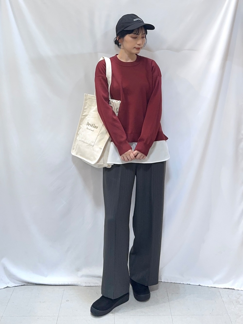 レッド系のニット/セーター、グレー系のその他パンツ、ブラック系のブーツを着用したレディースの秋コーディネートの4枚目の写真