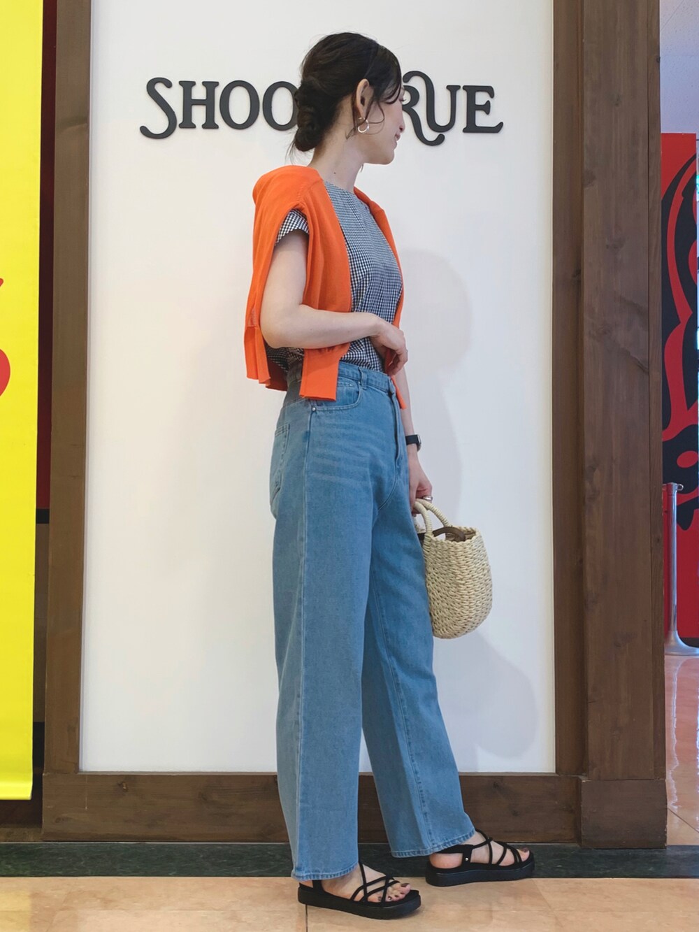 ブラック系のシャツ/ブラウス、ブルー系のデニムパンツ、オレンジ系のカーディガン/ボレロを着用したレディースの夏コーディネートの2枚目の写真