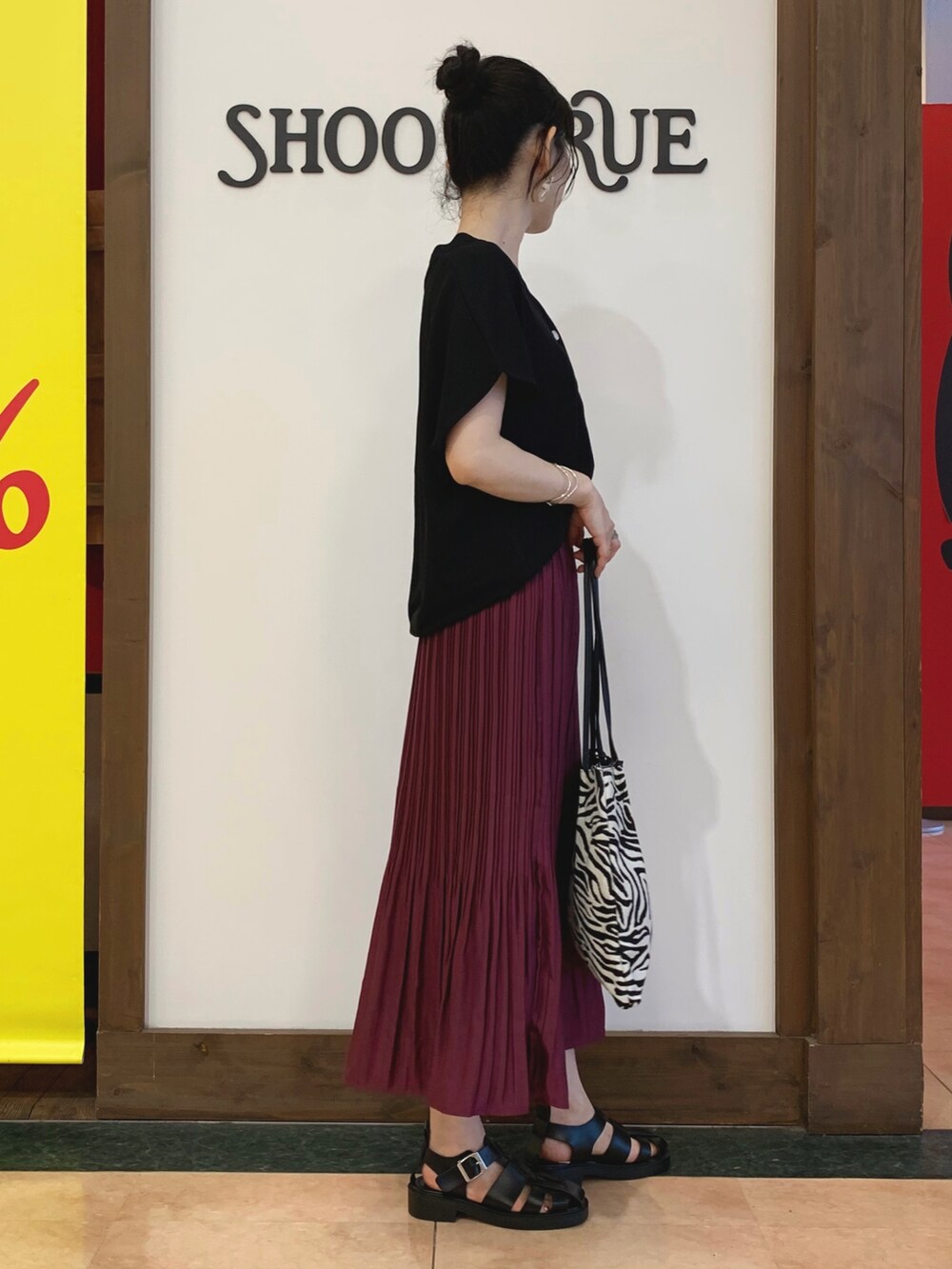 ブラック系のカーディガン/ボレロ、パープル系のスカート、ブラック系のトートバッグを着用したレディースの夏コーディネートの2枚目の写真