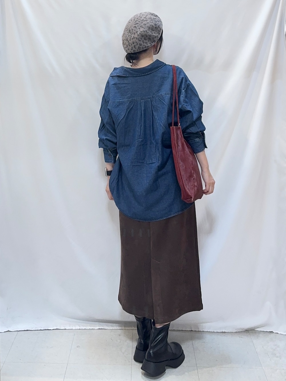 ブルー系のシャツ/ブラウス、グレー系のTシャツ/カットソー、ブラウン系のスカートを着用したレディースの秋コーディネートの3枚目の写真