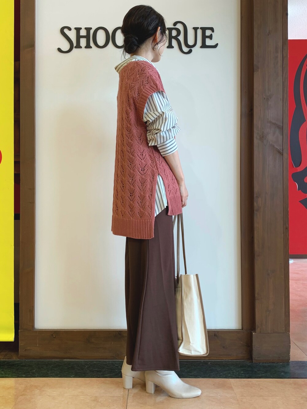 グレー系のシャツ/ブラウス、ピンク系のベスト、ブラウン系のスカートを着用したレディースの秋コーディネートの2枚目の写真