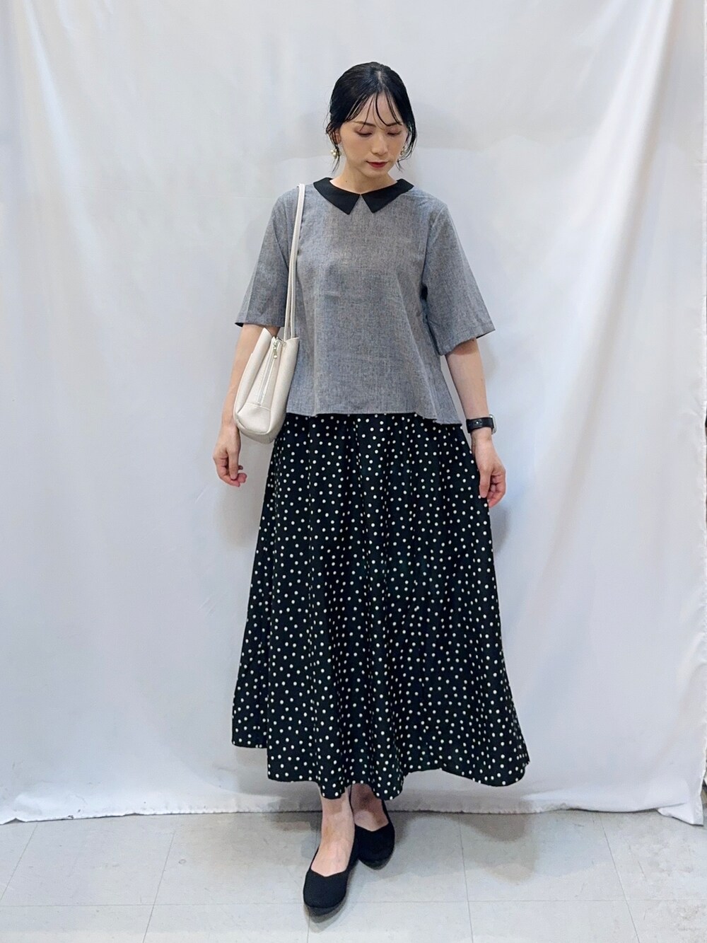 グレー系のシャツ/ブラウス、ブラック系のスカート、ブラック系のパンプスを着用したレディースの夏コーディネートの2枚目の写真