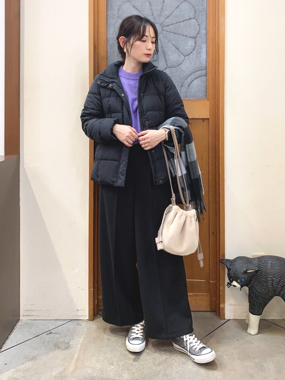 パープル系のニット/セーター、ブラック系のダウンジャケット/コート、ブラック系のその他パンツを着用したレディースの冬コーディネートの2枚目の写真