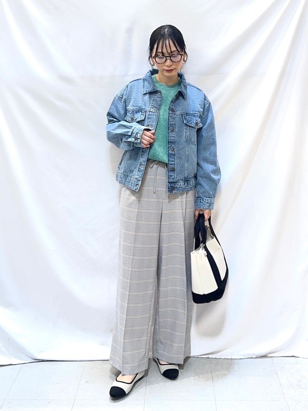 ブルー系のデニムジャケット、グリーン系のニット/セーター、ブルー系のその他パンツを着用したレディースの冬コーディネートの2枚目の写真