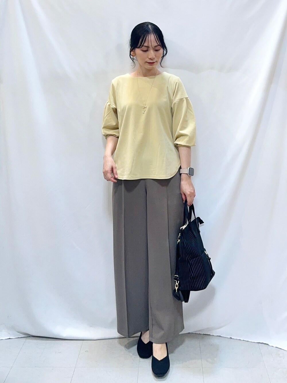 ブラウン系のその他パンツ、ブラック系のパンプス、ブラック系のバックパック/リュックを着用したレディースの秋コーディネートの4枚目の写真