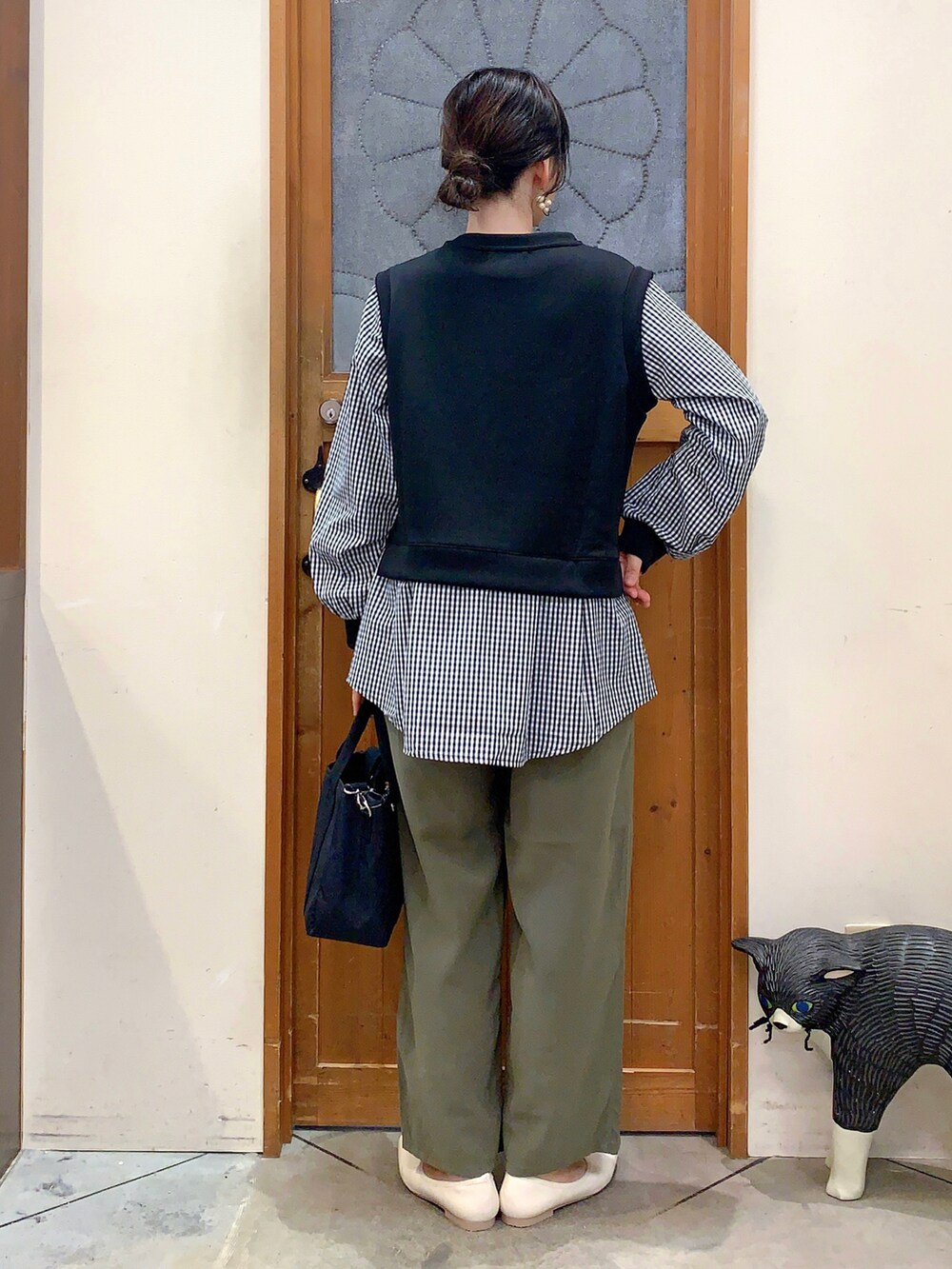 ブラック系のTシャツ/カットソー、グリーン系のその他パンツ、ブラック系のトートバッグを着用したレディースの春コーディネートの3枚目の写真