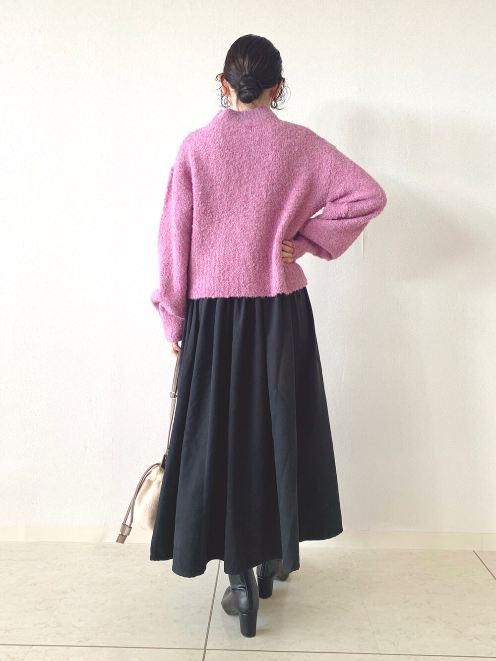 ピンク系のニット/セーター、ブラック系のスカート、ベージュ系のショルダーバッグを着用したレディースの秋コーディネートの3枚目の写真