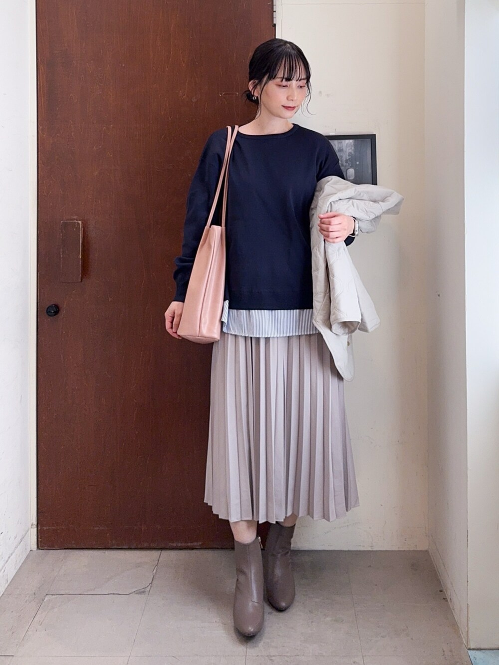 ベージュ系のブルゾン、ブルー系のニット/セーター、ベージュ系のスカートを着用したレディースの冬コーディネートの4枚目の写真