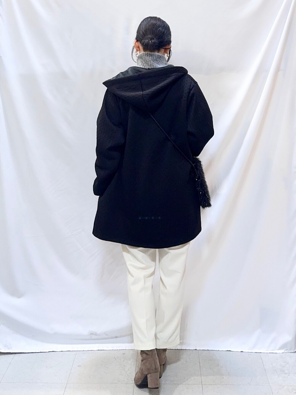 ブラック系のカーディガン/ボレロ、グレー系のニット/セーター、ホワイト系のその他パンツを着用したレディースの冬コーディネートの4枚目の写真