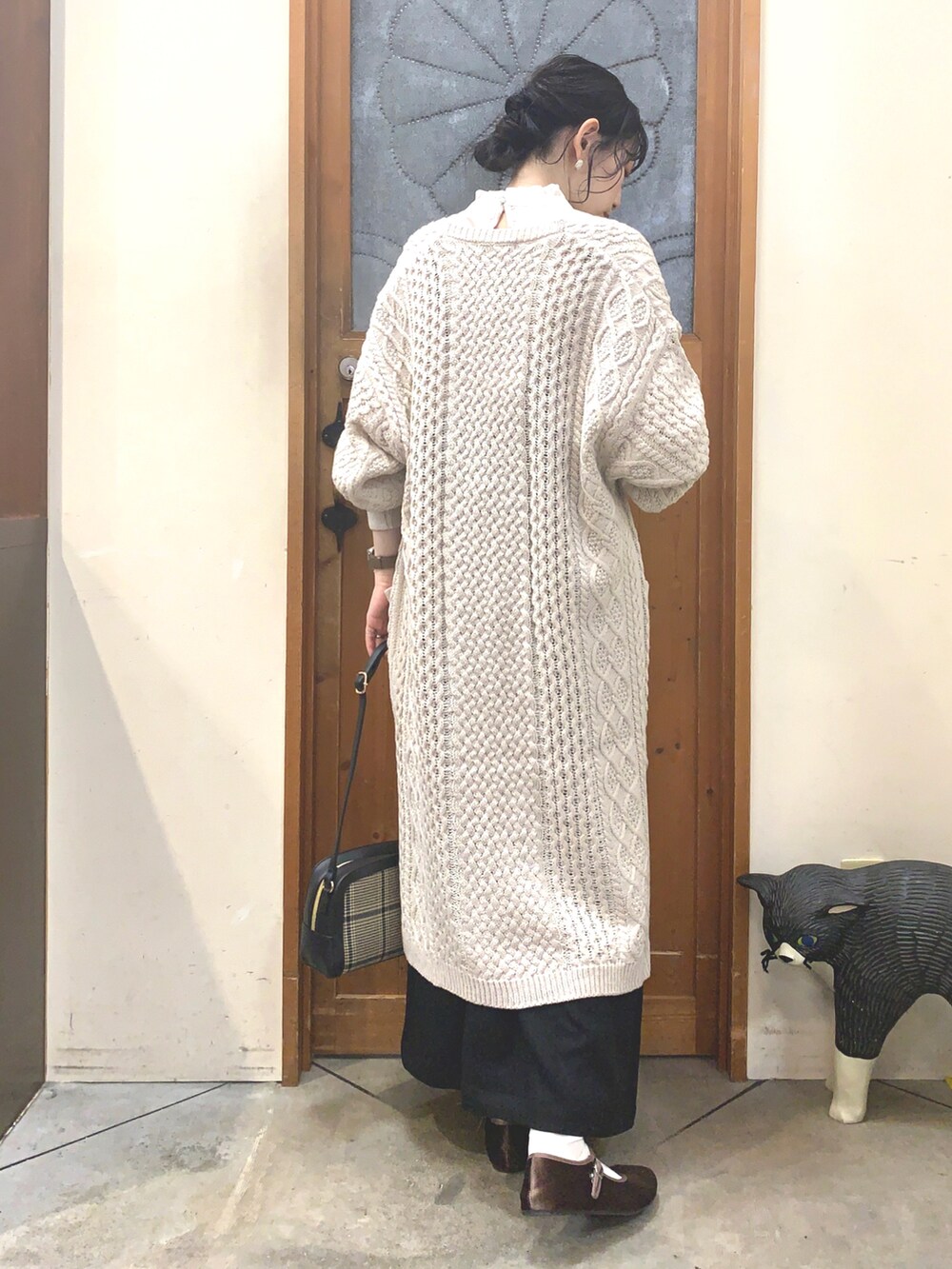 ブラック系のワンピース、ベージュ系のカーディガン/ボレロ、ベージュ系のシャツ/ブラウスを着用したレディースの秋コーディネートの3枚目の写真