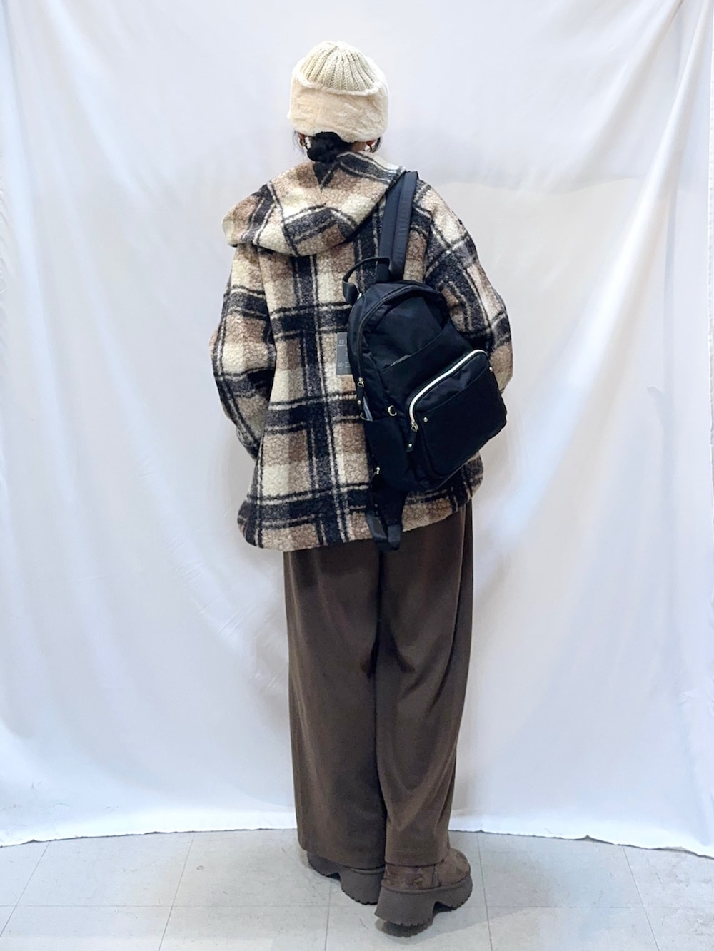 ブラウン系のその他アウター、オレンジ系のニット/セーター、ブラウン系のその他パンツを着用したレディースの秋コーディネートの3枚目の写真