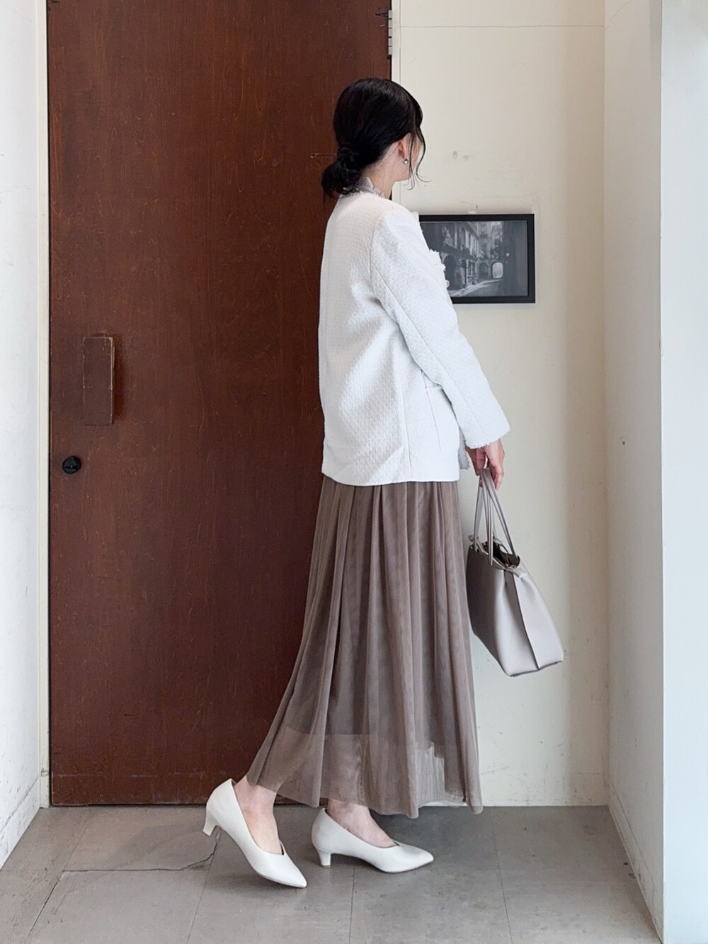 ベージュ系のノーカラージャケット、ベージュ系のシャツ/ブラウス、ブラウン系のスカートを着用したレディースの冬コーディネートの3枚目の写真