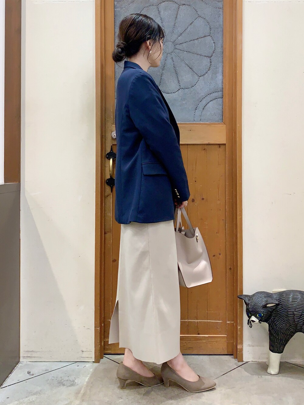 ブルー系のテーラードジャケット、ベージュ系のニット/セーター、ベージュ系のスカートを着用したレディースの春コーディネートの3枚目の写真