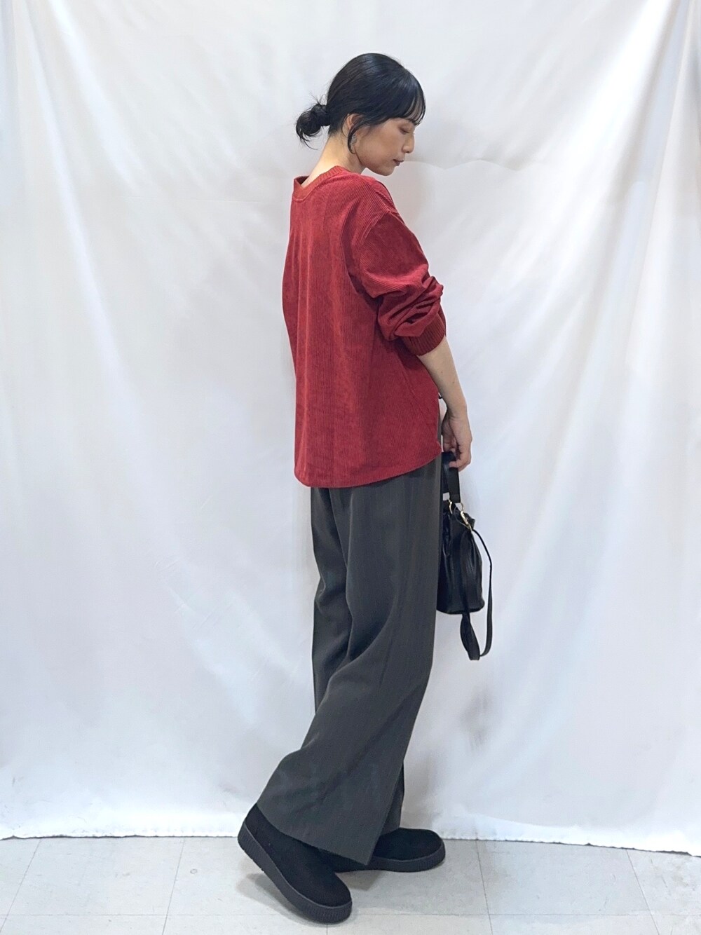 レッド系のTシャツ/カットソー、グレー系のその他パンツ、ブラック系のブーツを着用したレディースの秋コーディネートの2枚目の写真