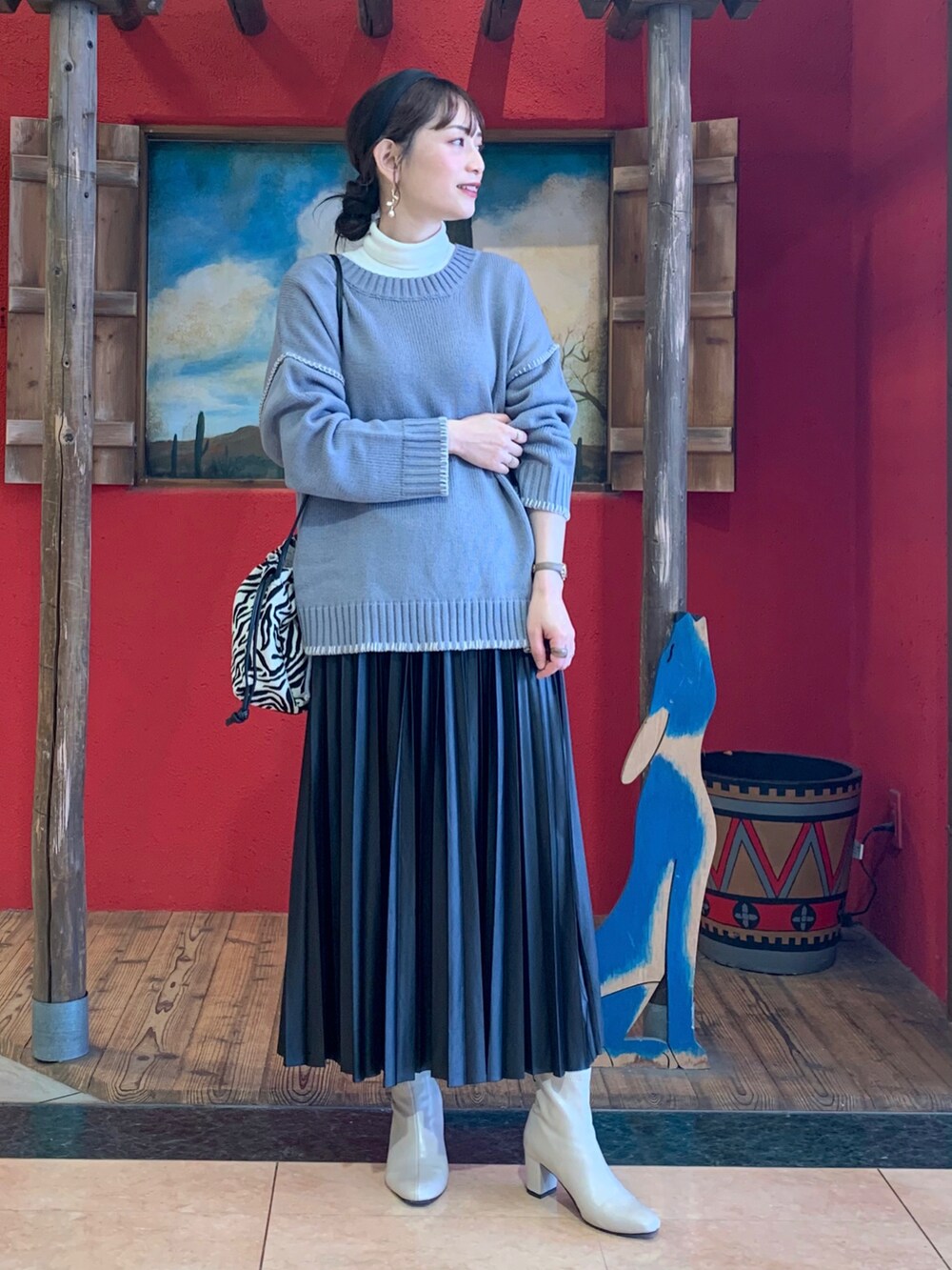 ブルー系のニット/セーター、ホワイト系のTシャツ/カットソー、ブラック系のスカートを着用したレディースの秋コーディネートの2枚目の写真