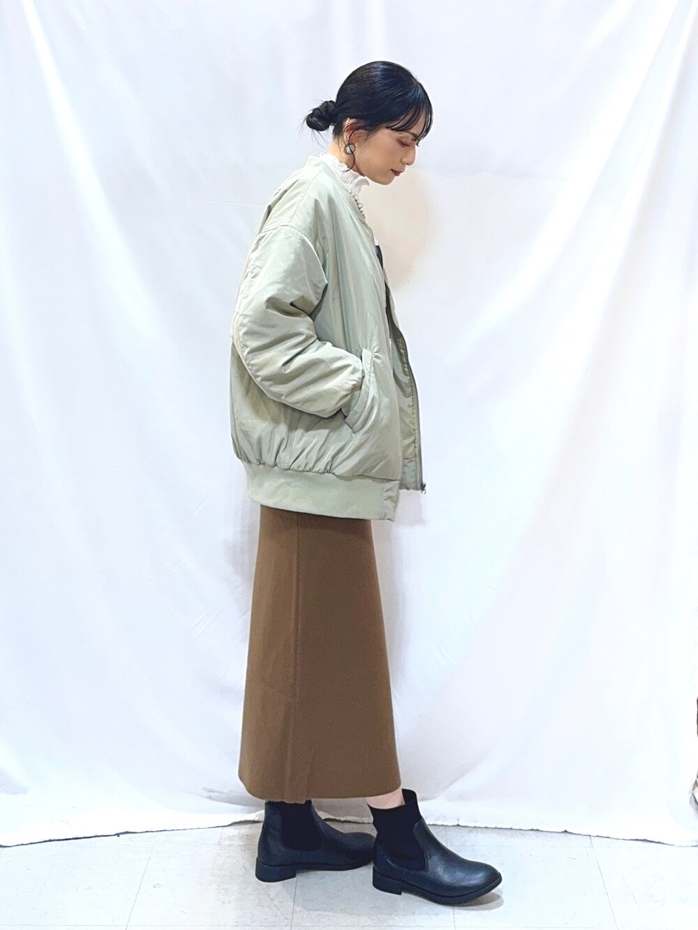 グリーン系のブルゾン、グレー系のスウェット、ホワイト系のTシャツ/カットソーを着用したレディースの冬コーディネートの3枚目の写真