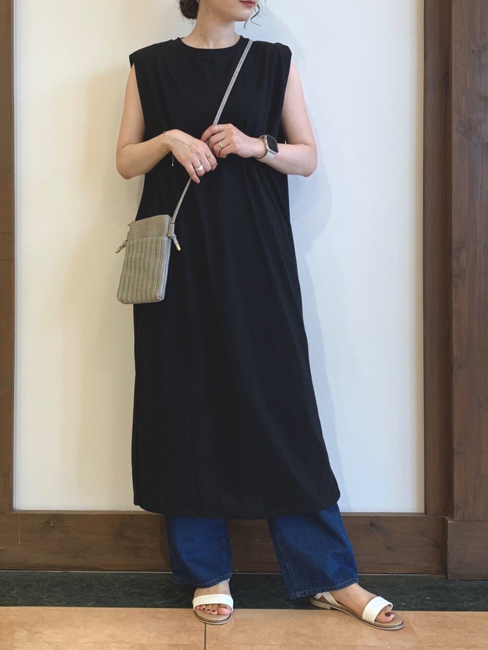 ブラック系のワンピース、ブルー系のデニムパンツ、ホワイト系のサンダルを着用したレディースの夏コーディネートの2枚目の写真