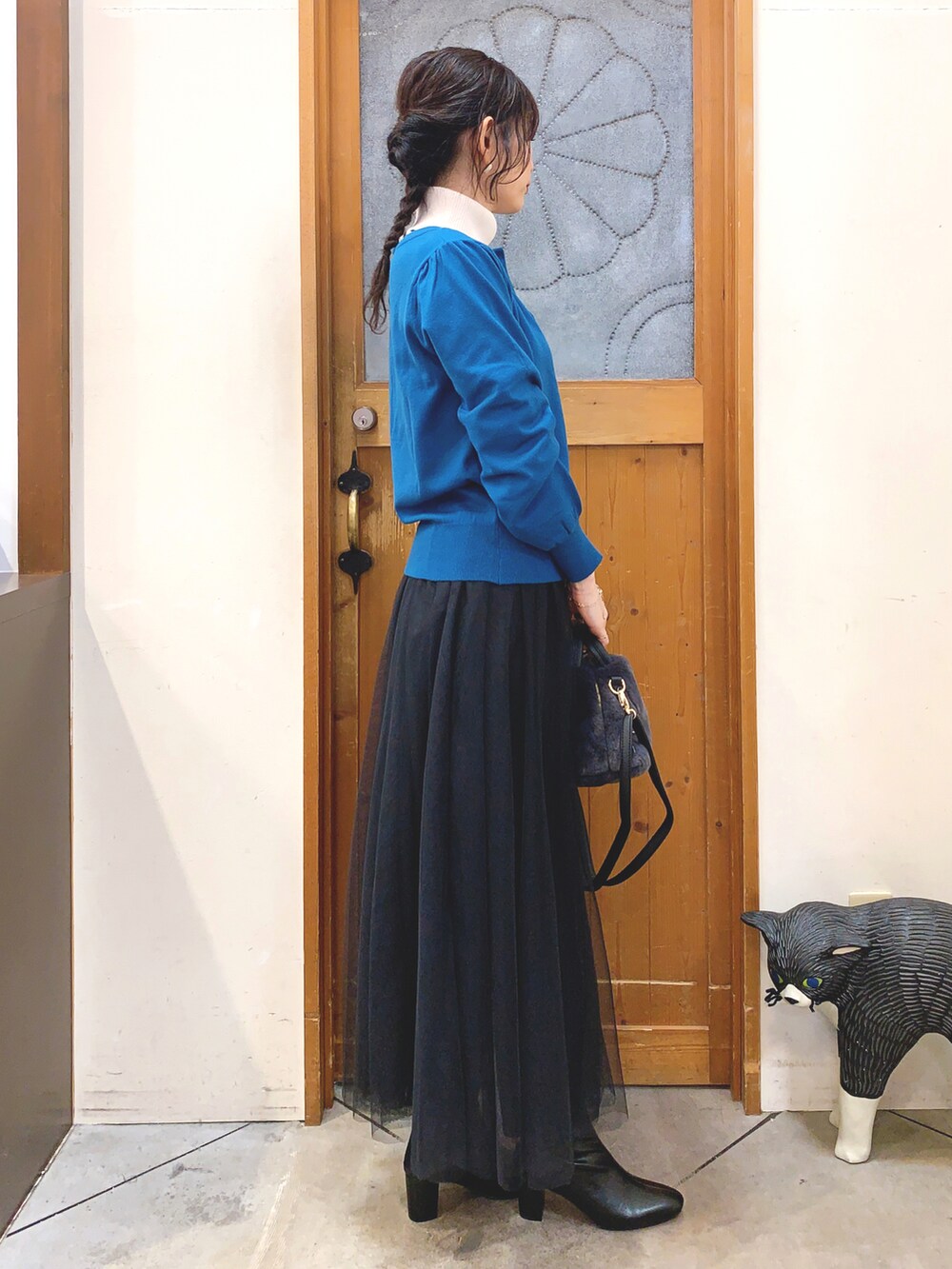 ホワイト系のニット/セーター、ブルー系のカーディガン/ボレロ、ブラック系のスカートを着用したレディースの冬コーディネートの3枚目の写真