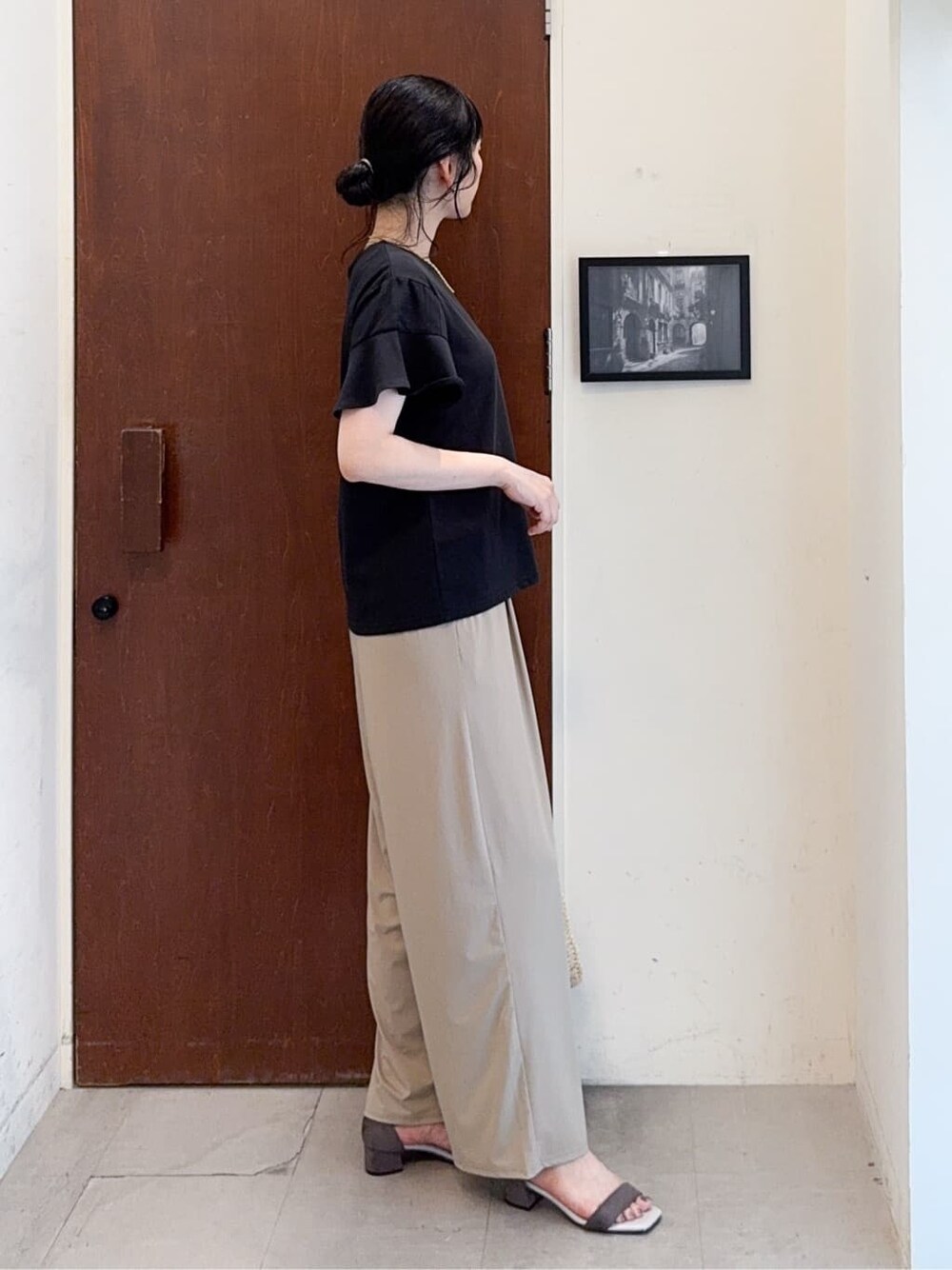 ブラック系のTシャツ/カットソー、ベージュ系のその他パンツ、ベージュ系のサンダルを着用したレディースの夏コーディネートの2枚目の写真
